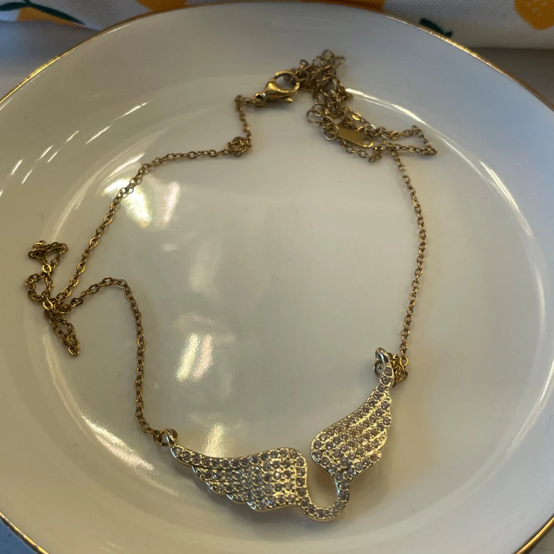 Guldigt halsband med glittriga vingar