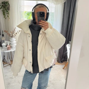 Vit pufferjacka  - Säljer en riktigt snygg vit pufferjacka från Levi's med hög krage och dragsko. Jackan har två stora fickor framtill, stängs med både dragkedja och knappar och har en oversized vibe. Perfekt för kalla dagar och riktigt trendig look.