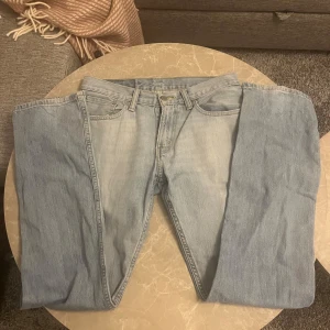 Levi's 514 ljusblå jeans W31 L34 - Säljer ett par klassiska Levi's 514 jeans i ljusblå denim. Modellen har rak passform, fem fickor och gylf med dragkedja.  Ikonisk läderpatch bak och röda Levi's-tag på bakfickan. Kom med bud eller frågor!