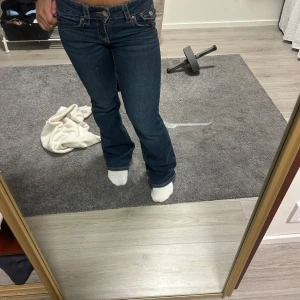 Mörkblå bootcut jeans med fickdetaljer - Snygga mörkblå jeans med bootcut passform och markerade sömmar. Byxorna har låg midja i ny sick storlek 152