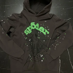 Sp5der Wait Web Hoodie Slate Grey - Inkl. Kvitto - Säljer nu min eftertraktade Sp5der Wait Web Hoodie i färgen Slate Grey. Detta är en 100% äkta tröja som jag köpte från MTHOR SHOP, och självklart finns kvittot som bevis på äktheten. Jag har tyvärr vuxit ur den, men den har bara använts ett fåtal gånger och är i helt felfritt skick – det finns verkligen inget slitage eller några defekter alls. Passa på att fynda denna sällsynta hoodie!