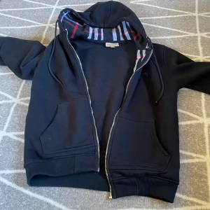 Svart Burberry hoodie zip - Säljer min burbbery zip på min grund av att den inte passar längre o kedjan har gått sönder men det går att fixa kedjan bara att jag inte har tid o den passar endå inte mig därför säljs den billigt 