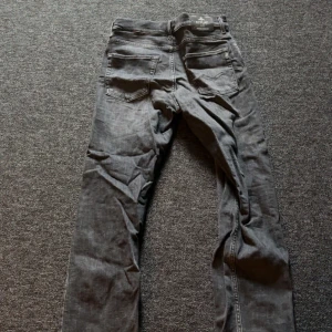 Grå jeans från Replay, storlek 14A - Säljer ett par grå jeans från Replay i klassisk femficksmodell. Jeansen har raka ben och normal passform, med snygga detaljer och tydliga sömmar. Perfekta för dig som gillar stilrena och enkla jeans med en cool vibe.