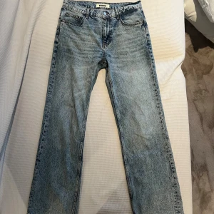 Mid blue, raka jeans från Woodbird - Snygga mid blue jeans från Woodbird med klassisk femficksdesign och raka ben. Jeansen har en tvättad look och normal passform, perfekta för en avslappnad stil. Storlek 31/32