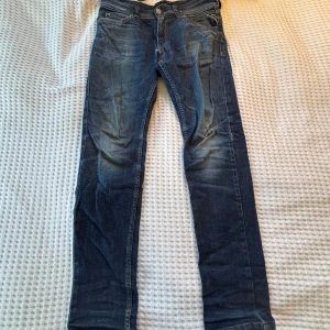 Blå Replay jeans Slim fit - Säljer ett par klassiska blå jeans från Replay med snyggt slitna detaljer. Slim fit i storlek 12A, passar dig som är runt 150-160 cm. Hör av dig vid intresse av fler bilder eller frågor😊