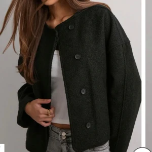 Svart teddy liknade jacka  med knappar - Säljer en svart teddyjacka med rund hals och fyra knappar framtill. Jackan har en loose passform och är helsvart med mjukt, fluffigt material på utsidan och slät insida. Perfekt för dig som gillar en chill och stilren look. Den är helt ny och inte alls använd. Pris 200kr men pris går att diskutera vid driekt köp! 