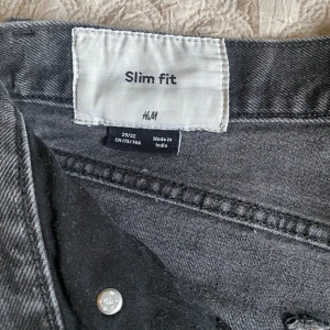 Grå slim fit jeans från H&M - Snygga grå slim fit jeans från H&M i klassisk femficksmodell. Jeansen har en smal passform och är tillverkade i ett mjukt bomullsmaterial med lite stretch för extra komfort. Perfekta till en avslappnad stil och funkar året runt.