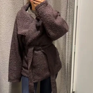 Brun teddyjacka med bälte - Mysig brun teddyjacka med bred krage och knytbälte i midjan. Jackan har en oversized passform och långa ärmar, storlek XXS men passar från XS-S. Slutsåld 