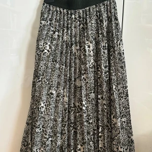 Grönvit långkjol från H&M, stl 34 - Säljer en svartvit långkjol från H&M i storlek 34. Kjolen har ett coolt abstrakt mönster, bred resår i midjan och är plisserad för extra volym. Den är fodrad med ett vitt innerfoder för att inte bli genomskinlig. Perfekt för dig som gillar statement-plagg!