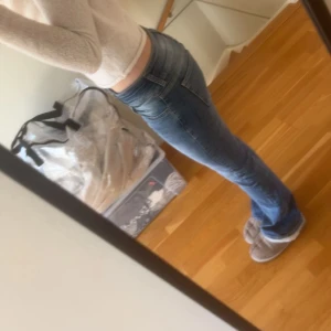 Blå bootcut jeans låg midja - Snygga blå jeans med bootcut och låg midja. Jeansen har klassisk femficksdesign och är tillverkade i denim med lätt slitning på låren. Perfekta för dig som gillar en avslappnad men ändå trendig look.