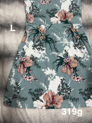 Blommig klänning i pastell - Superfin klänning med blommigt mönster i pastelliga toner av grönt, vitt och rosa. Klänningen har en markerad midja och utsvängd kjol, perfekt för varma dagar. Mjukt och bekvämt material som känns skönt mot huden.🌸 Sparsamt använd. Storlek L