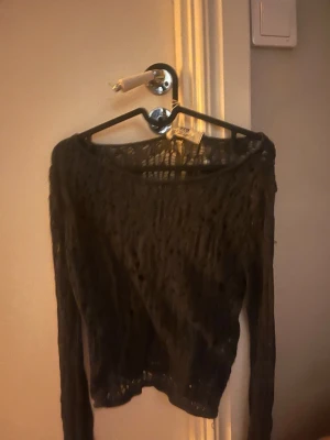 Svart stickad tröja från STR Teen - Svart långärmad stickad tröja från STR Teen i storlek S. Tröjan har ett snyggt hålmönster och är lite transparent, perfekt för att skapa en cool lager-på-lager look. Rund hals och mjukt material som känns skönt mot huden. Så snygg fest topp över ett linne 🍾är ganska bagy på men det är så snyggt 