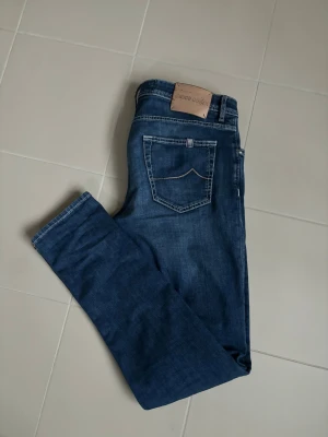 Jacob Cohen jeans nyaste modellen - Blå eleganta och riktigt snygga populära Jacob Cohen jeans i w38 (midjemått på 90 cm). Superfint skick verkligen utan hål eller fläckar och passar till allt, dem perfekta trendiga jeansen verkligen och tveka inte vid minsta fråga eller fundering🤩
