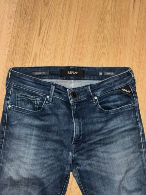 Replay Hyperflex New Luz jeans blå - Snygga Replay Hyperflex New Luz jeans i mörkblå tvätt med lätt slitning. Modellen är skinny fit med klassisk femficksdesign och stretchigt material för extra komfort. Perfekt passform och stilren look. Är lite uttöjda i rumpan annars inga defekter