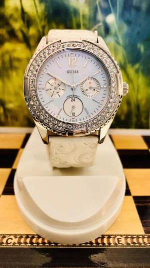 Snygg klocka från Guess - Säljer en vacker Guess damklocka. Klockan har ett quartz urverk och en stilren display. Boetten är tillverkad av rostfritt stål och armbandet aningen slitet men fortfarande i användbar skick är gjort av äkta läder. Denna klocka har en kronograf funktion och är vattentålig till 30 meter. Detaljer som den silverfärgade boetten och det vita armbandet ger klockan en sofistikerad look. Rustad med nytt batteri, säljes i befintligt fungerande skick enligt bilderna!