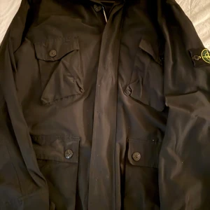 Stone Island Fieldjacka - En riktigt schysst stone island fieldjacka i bra skick i svart färg🎨 Köpt av en vän för länge sedan men nu börjar den bli för liten så tänkte skicka iväg den till någon som använder den mer😁OBS! Lapparna blev klippta i samband när jag köpte jackan. Vid frågor skicka iväg ett dm till mig. 