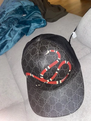 Svart Gucci kingsnake keps - Säljer en svart Gucci kingsnake keps i storlek S, självfallet äkta vid frågor kom i dm