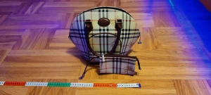 Rutig handväska från Burberry - Säljer en rund handväska från Burberry med klassiskt rutigt mönster i beige, svart, rött och vitt. Väskan har bruna handtag i skinn och en söt fjärilsberlock på dragkedjan. Medföljer en matchande liten plånbok med samma mönster och brunt band. Perfekt för dig som gillar ikonisk design. Om man inte vill ha båda kan man köpa de separata, 1400kr för den stora. Eller 800kr för den lilla.