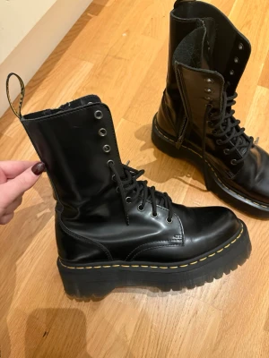 Dr. Martens  - Dr. Martens i svart skinn med grov plattformssula och klassisk gul söm. Höga skaft med snörning och dragkedja på sidan för enkel påtagning. Endast använda en gång 🤭