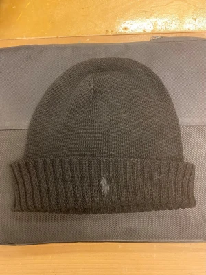 Svart polo mössa - Säljer en hel svart polo ralph lauren mössa, med deras ikoniska mönster och fina logga. OBS PRIS OCH FLER BILDER DISKUTERAS 