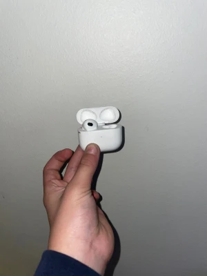 AirPods Pro - Apple AirPods Pro trådlösa hörlurar med laddningsetui. Snygg och kompakt design, aktiv brusreducering och transparensläge. Skicket ser bra ut med mindre ytliga repor på etuiet, inga synliga större skador. Perfekt för musik, samtal och träning.
