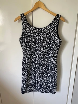 Mönstrad klänning från  - Snygg ärmlös klänning med svart och vitt leopardmönster. Modellen är figurnära och har rund halsringning. Perfekt för dig som vill sticka ut med ett coolt mönster. Står storlek 44 men upplevs mer som 40🤍