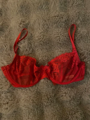 Röd bh från twilfit - Modellen har justerbara axelband och ett hjärtformat dekor vid bygeln. Perfekt för dig som gillar snygga och unika underkläder med extra detaljer. 