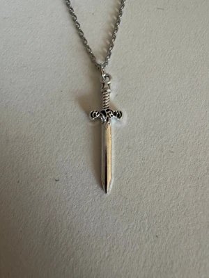 Silverhalsband mindre svärd  - Perfekta julklappen 🌲  Säljer smycken som skapats som hobby av mig och dottern.   Halskedjor är 50cm.  Bilder på berlock kan vara missvisande så är det viktigt så fråga gärna om mått 🌹  Smycken är inte av äkta guld/silver .   Inga bud godtas då priserna är så billiga❤️