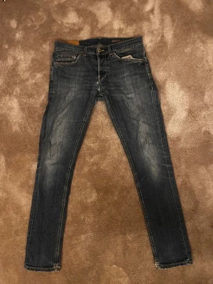 Dondup George  - Säljer ett par dondup George i mörkblå tvätt med snygga slitningar. Jag säljer dom då dom inte kommer till användning så mycket. Perfekt för dig som gillar en modern look.