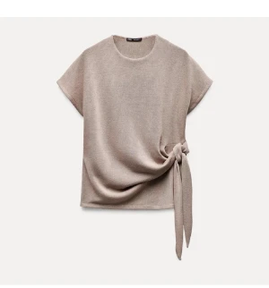 Beige topp med knyt från Zara - Stilren beige topp från Zara med korta ärmar och rund halsringning. Toppen har en snygg knytdetalj i sidan som ger en modern och avslappnad look. Perfekt att matcha med jeans eller kjol för en trendig outfit. Obs de e storlek s men passar xs också!