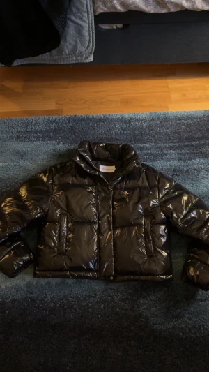 Svart pufferjacka från Calvin Klein Jeans - Säljer en svart, glansig pufferjacka från Calvin Klein Jeans med CK-logga på bröstet. Jackan har hög krage, två stora fickor framtill och dragkedja. Perfekt för kalla dagar och har en riktigt snygg streetstil. Pris kan diskuteras! Kom gärna med frågor 