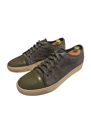 Lanvins i storlek 44 - Snygga sneakers från Lanvin med grå mocka på sidorna och olivgröna detaljer i skinn på tån och snörningen. Beige platt sula och rund tå ger en clean look. Kommer med original dustbag från Lanvin. Perfekt för dig som gillar stilrena och exklusiva sneakers.