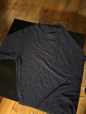 Mörkblå t-shirt från Cotton Line - En enkel och stilren mörkblå t-shirt från Cotton Line. T-shirten har rund hals och korta ärmar, tillverkad i mjuk bomull som känns skön mot huden. Perfekt för dig som gillar en clean och klassisk look.