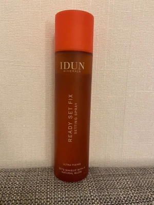 IDUN Minerals Ready Set Fix Setting Spray - Ready Set Fix Setting Spray från IDUN Minerals i en snygg orange plastflaska på 100 ml. Ultra fixing formula som ger en naturlig glow och håller sminket på plats hela dagen. Vegansk och tillverkad av återvunnen plast. Perfekt för dig som vill ha ett fräscht och hållbart resultat. Använt några få tal gånger men annars som ny, kostar i ny pris runt 200kr