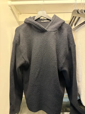 Svart stickad hoodie från Bik Bok - Mysig svart hoodie från Bik Bok med grovstickad känsla och ribbade muddar vid ärmslut och nederkant. Modellen har en stor huva och är lite oversized. Använd en gång så väldigt bra skick 