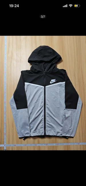 Nike mjukisbyxor svart/grå med snörning - Nike mjukisbyxor i svart och ljusgrått med coolt tvåfärgat mönster framtill. Byxorna har elastisk midja med snörning, muddar vid benslut och Nike-logga på vänster lår. Materialet är mjukt och syntetiskt, perfekt för chill eller träning.