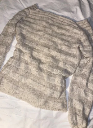 Tjocktröja med ränder - Denna beige/vita ull tröjan är så himla fin. Den är lite lätt off shoulder vilket jag älskar. Jag tror det är ull (typ 100% säker men kan inte lova) och kan vara hemma stickad. Passar perfekt nu till vintern som ett basic men ändå detaljerad varm tröja. Vet verkligen inte vad det är för storlek eftersom det helt beror på hur baggy man vill ha den m.m, men chansar på att den är typ en M. #ull #hemmastickat #cozy #randig #vinter #off shoulder #tjocktröja