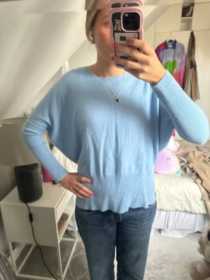 Ljusblå kashmirtröja från Notshy - Lusblå kashmirtröja från Notshy med rund hals och ribbade muddar. Tröjan har en loose passform och långa ärmar, 