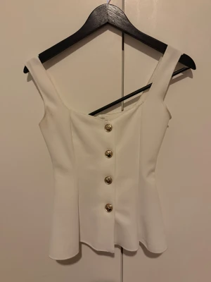 Topp zara  - Snygg vit linnetopp med breda axelband och fem guldfärgade knappar framtill. Toppen har en figurnära passform. Köpt på zara i paris 