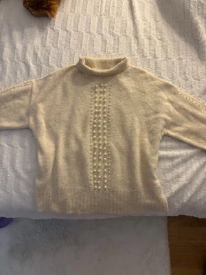 Beige Pearl Knit Sweater  - Super cute beige knitted sweater with pearl details on the front and sleeves. Very soft and warm so it’s perfect for fall/winter. Worn only once or twice so it’s in excellent condition. Says size XS ! 