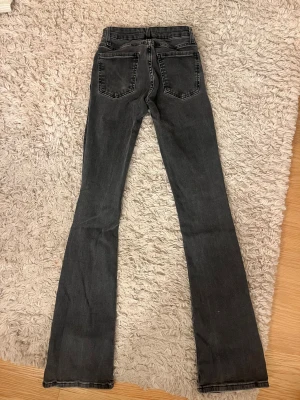 Svarta bootcut jeans från Zara - Snygga svarta jeans från Zara med bootcut passform och klassisk femficksdesign. Jeansen har hög midja och är tillverkade i stretchigt denim för en bekväm känsla. Dom är lågmidjade. Jag är 168 och passar mig perfekt i längden 