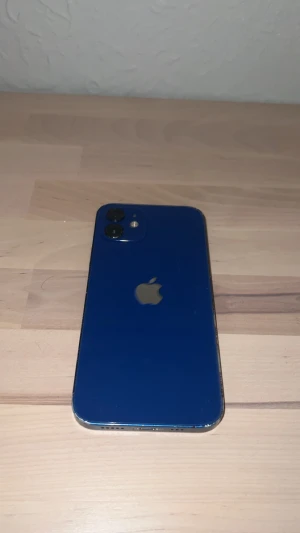 iPhone 12 Blå - Snygg blå iPhone 12 med 64GB lagring. Skärmen har synliga repor och slitage, men mobilen fungerar utmärkt. Batterihälsa på 78%. Dubbelkamera för skarpa bilder, Face ID och iOS 17 installerat. Perfekt för dig som vill ha en prisvärd iPhone med bra prestanda.