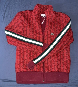 Lacoste Zip Vinröd - Sällsynt Vinröd Lacoste zip tröja som är i god skick, inget fel med den alls. Storlek S. Priset går att diskuteras.