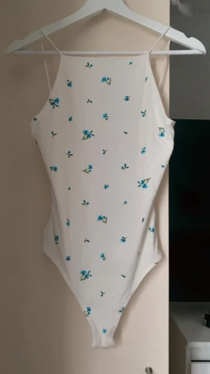 Blommig body stl S - Body från HM i stl S. Några år sen inköp men enbart använd 1-2 ggr. U-ringning i ryggen och lite högre vid halsen. Lite trasig i sömnen på två ställen men det är knappt märkbart, se bilder.