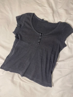 Jättesöt randig brandy baby tee  - Denna mörkblå/grå topp är så himla fin och är den perfekta modellen. Jag älskar ärmarna och knapparna så mycket. Passar superfint till typ allt och alla årtsider! #baby tee #randig #knappar #2000s