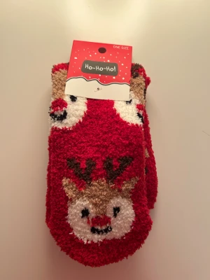 Röda fluffiga julstrumpor med renmotiv från Normal  - Supermjuka och mysiga röda strumpor med renmotiv i vitt, brunt och svart från Normal. 