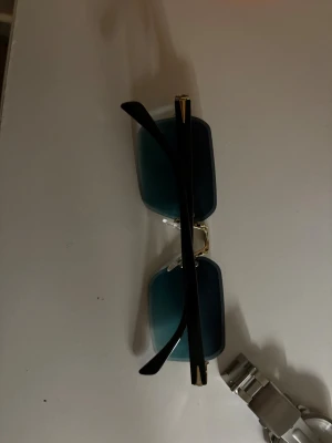 Geneva silverfärgad klocka med svart urtavla i köpet så får man ett par solglasögon  - Stilren klocka från Geneva med silverfärgat metallarmband och svart urtavla med romerska siffror. Klockan har rund boett och klassisk länkdesign som ger en snygg vibe. Perfekt accessoar för dig som gillar en clean look. 