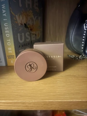 Anastasia Beverly Hills Cream Bronzer Amber - Cream bronzer i färgen Amber från Anastasia Beverly Hills. Kommer i en rund, beige plastburk med logotyp på locket och tillhörande kartong. Konsistensen är krämig och färgen är varm, medium-brun som ger en naturlig solkysst look. Vegansk och cruelty-free. Produkten är använd men bara två gånger, säljer då färgen inte passar mig. 
