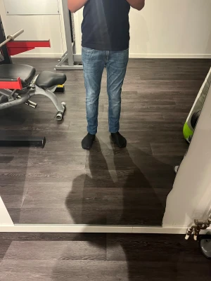 Replay Anbass blå jeans slim fit - Snygga Replay Anbass jeans i klassisk blå tvätt med lätt slitningar. Slim fit-modell med raka ben och fem fickor. Märkespatch i läder baktill och Replay-logga på fickan fram. Perfekt passform för dig som gillar stilrena jeans med modern känsla.