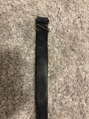Svart Louis Vuitton bälte  i skinn - Säljer ett svart Louis Vuitton bälte i äkta skinn med klassiskt monogrammönster och en snygg LV-spänne i silver. Kvitto finns ifall man vill få det med, strl 80/32. Reversibel belt. Jag köpte det för 5850kr, säljer nu för 2000kr. Säljer för att det inte passar längre . Kontakta om du har frågor , pris kan diskuteras!